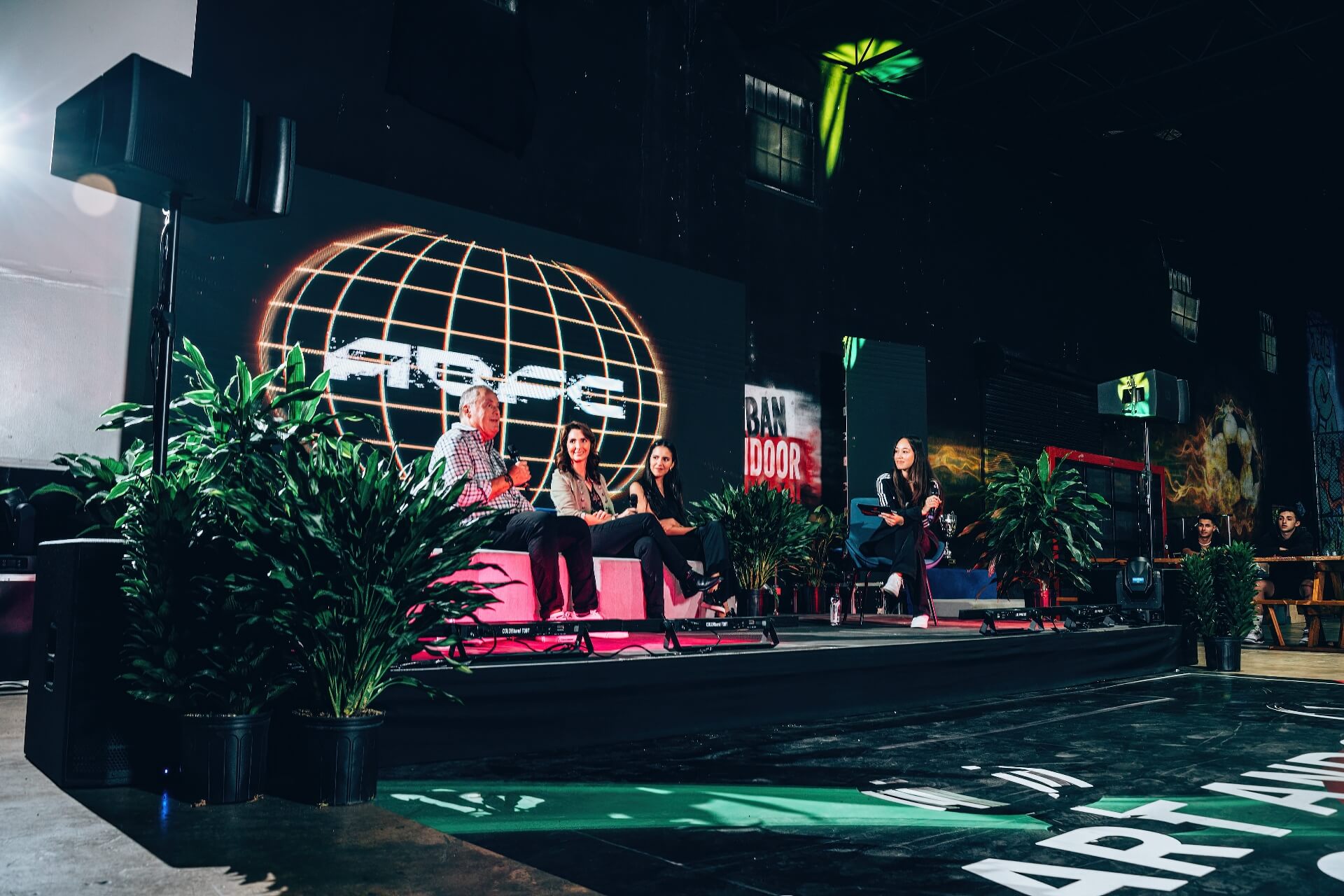 Corporate Event Production Audio Visual Rental Setup Panel speakers on an indoor conference stage with a professional LED video wall backdrop, stage lighting, and sound system speakers for premium corporate event production rentals.